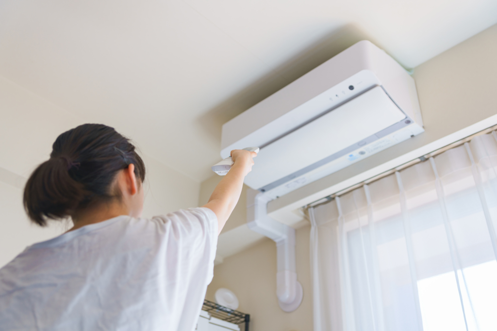 A woman controlling her air conditioner