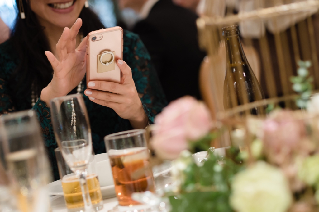 婚禮上一邊吃飯一邊開心滑手機的女子
