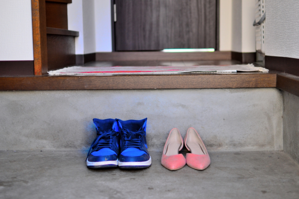 藍色球鞋與粉色跟鞋並排在玄關