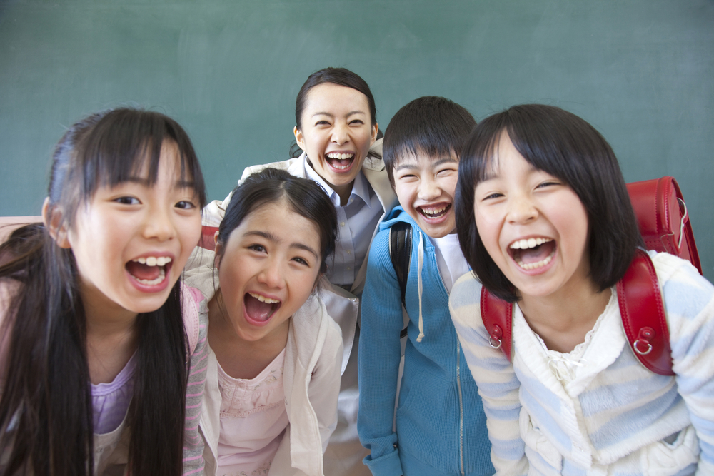 Japanese students and teacher smiling at camera