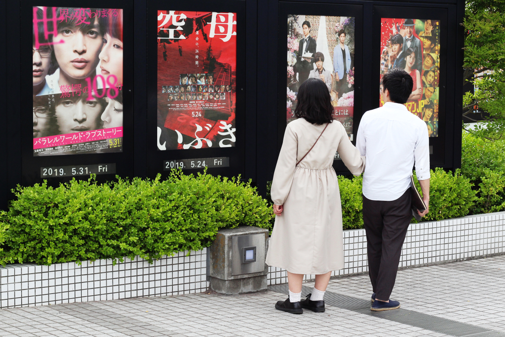 站在一排電影海報前觀看的情侶