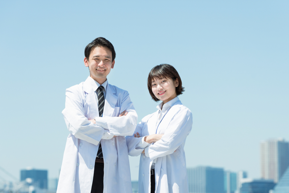 Smiling male and female doctors in white coats
