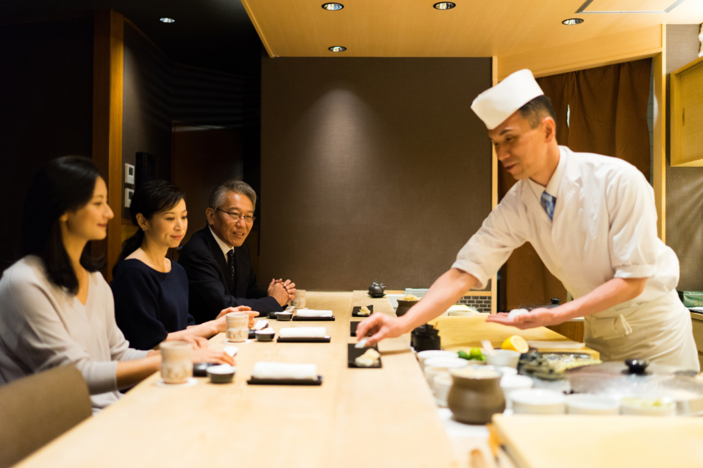 đầu bếp đang phục vụ sushi tại nhà hàng