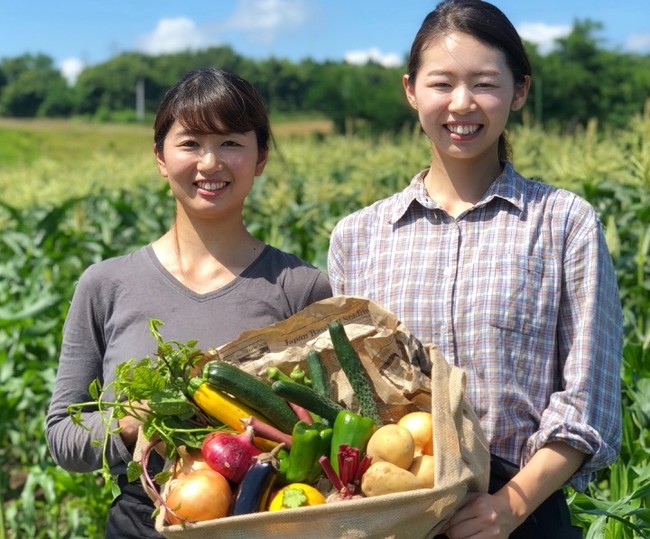 兩個農夫燦笑捧著蔬果籃